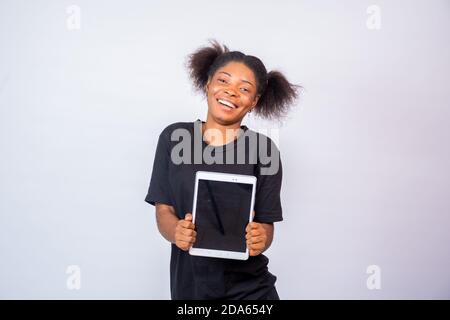 happy young african lady holding a tablet computer with the screen facing forward Stock Photo