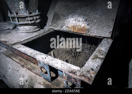 Concrete mixer with pouring cement at the construction site. Close up on concrete mixer, cement mortar mixing. Stock Photo