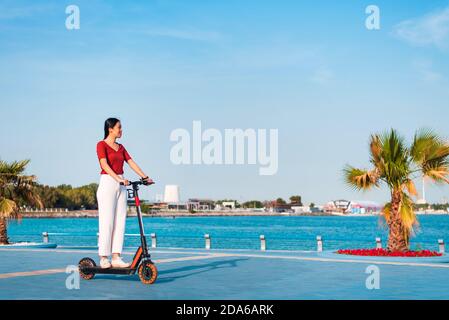 Woman having a ride on electric scooter for quick and easy transportation in a modern city life Stock Photo