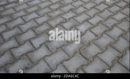 Concrete products; Construction industry; Paved ground. Interlocking paving with gray and white concrete blocks. Stock Photo