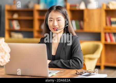 Smiling chinese support service agent consulting customer. Female portrait looking at camera Stock Photo