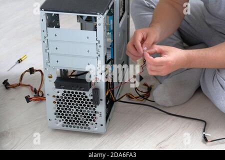 Service electronics and computers concept. Repairman is fixing computer using tools. Stock Photo