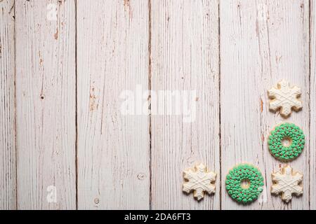 Christmas decorated sugar cookies forming a border on a wood surface with copy space and room for text Stock Photo