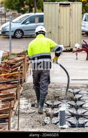 Construction worker using safety rules is working on a reinforced concrete slab pouring concrete Stock Photo