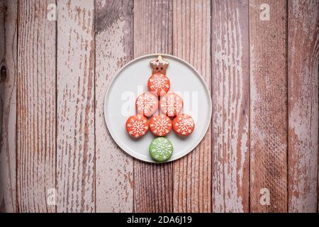 Christmas tree made of decorated macarons macaroons on a textured wood background with copy space and room for text Stock Photo