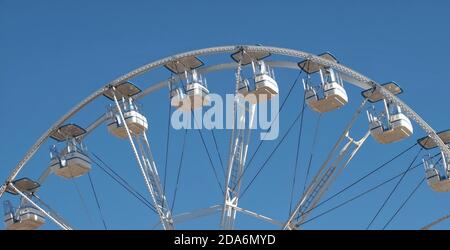 Empty white ferris wheel in front of blue sky Stock Photo