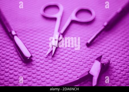 Set of professional manicure tools on white table. Violet tone. Stock Photo