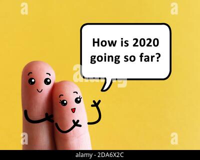 Two fingers are decorated as two person. One of them is asking another about how is his 2020 going so far. Stock Photo