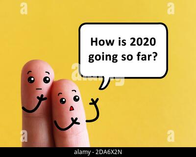 Two fingers are decorated as two person. One of them is asking another about how is his 2020 going so far. Stock Photo