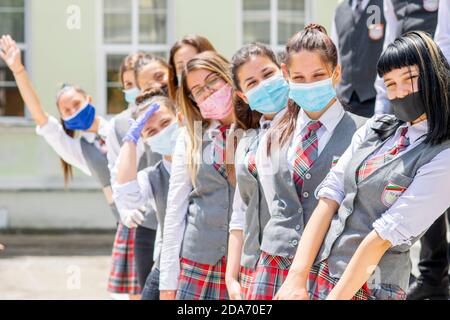 Sliven, Bulgaria - June 11th 2020: Girls preparing for high school graduation during Covid-19 coronavirus social distancing, wearing face covering / m Stock Photo