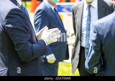 Politicians or businessmen talking at meeting wearing protective gloves and masks during coronavirus COVID-19 pandemic Stock Photo