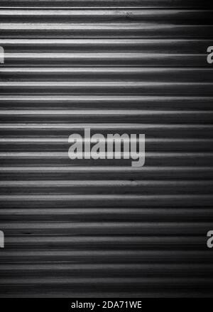 New, clean and corrugated wooden wall, viewed from the front. Light coming from above. High resolution full frame textured background in black&white. Stock Photo