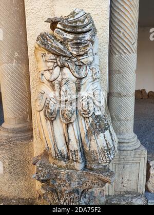 Vertical shot of a headless statue in the famous Roman ruins in Timgad, Algeria Stock Photo