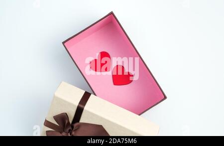 Two red hearts in an open gift box on a light background. Stock Photo