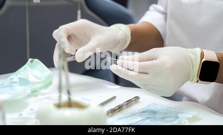 Young woman dentist Prepares the instrument for the patient Stock Photo