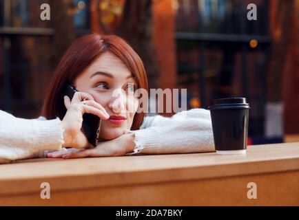 Woman hanging on a phone with raised brows expression on her face. Chatting with friends concept. Stock Photo