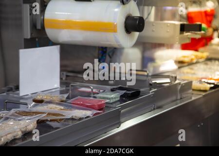 Linear tray food heat sealing and packaging machine Stock Photo