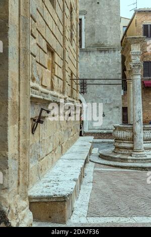 detail of marble bench and well at Piccolomini Renaissance palace in historical little town, shot in bright light at Pienza, Siena, Tuscany, Italy Stock Photo