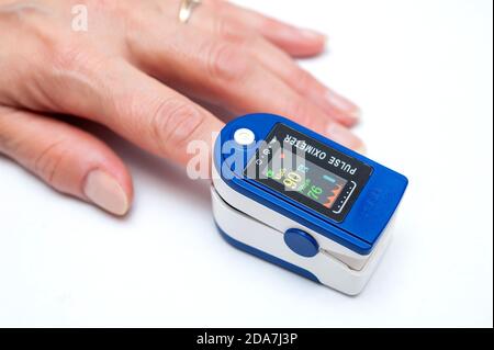 Close up of Finger in an Oximeter Device. Pulse oximeter on white background. Stock Photo