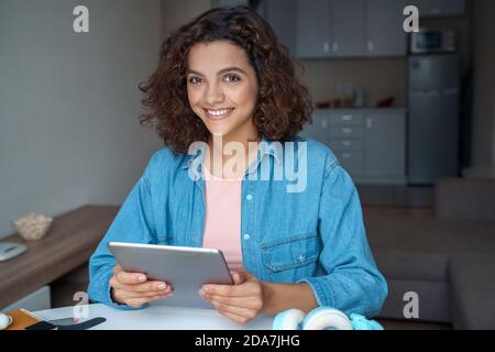 Hispanic young woman using tablet and looking at camera. Stock Photo