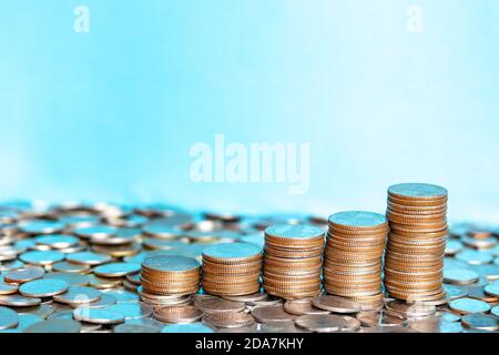 Close up silver coins, golden coins stacked on each other in different positions. A pile of Coins on baht coin background. Money-saving concept. Stock Photo