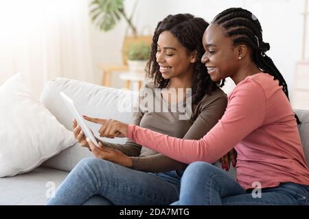 African american girlfriends using digital tablet together Stock Photo