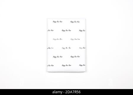 Xmas present wrapped in paper with festive prints. Christmas gift on white background. Homemade bright Christmas present box Stock Photo