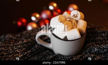 Christmas hot chocolate with marshmallows on a table with red christmas balls on background. Selective focus Stock Photo