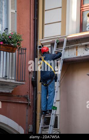 terni,italy october 14 2020:man standing on top of a ladder to work Stock Photo