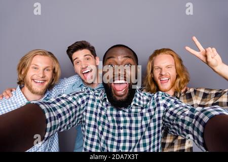 Self-portrait of four nice attractive funky cheerful cheery positive guys embracing having fun meeting classmates showing v-sign fooling isolated over Stock Photo