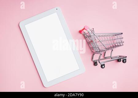 Mini shopping cart and tablet with empty white screen Stock Photo