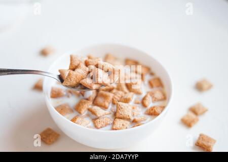 Dry breakfast cereal pads with milk on a white concrete background  Stock Photo