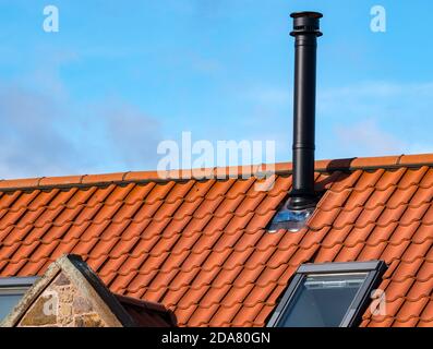 Flue for wood burning stove on house pantile roof in converted old farm  building dated 1857, East Lothian, Scotland, UK Stock Photo - Alamy