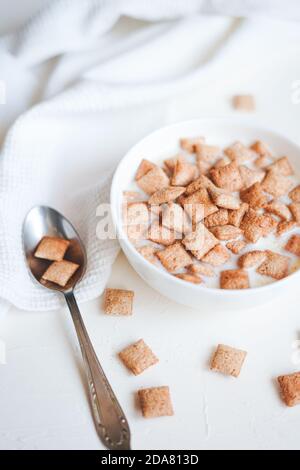 Dry breakfast cereal pads with milk on a white concrete background  Stock Photo