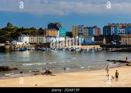 TENBY, WALES, UK - SEPTEMBER 14 2020: People enjoying late summer sunshine on a sandy beach in the picturesque seaside town of Tenby, Wales Stock Photo