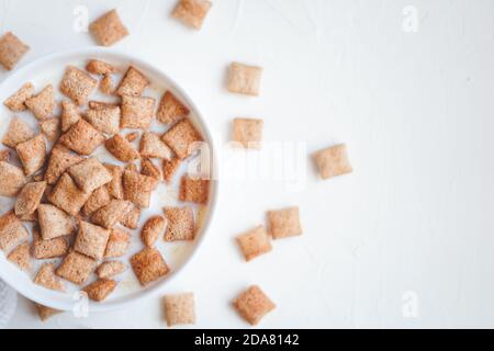Dry breakfast cereal pads with milk on a white concrete background  Stock Photo