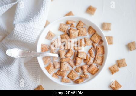 Dry breakfast cereal pads with milk on a white concrete background  Stock Photo