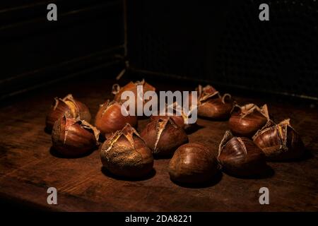 Sweet chestnuts, Castanea sativa,  in the oven on a stoneware plate, ready to eat Stock Photo