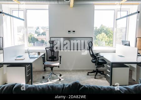 Empty office space while officer is working from home to avoid corona virus. Open space office in loft style in new normal. Working In An Empty Office Stock Photo