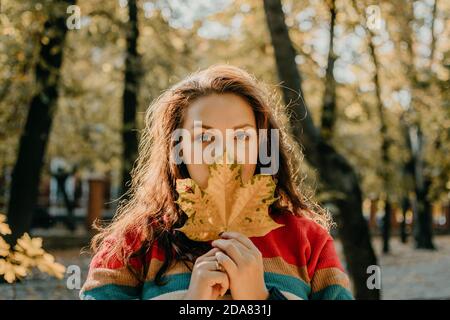 Body Shaming, Low self-worth concept. Sad plus size woman walking in autumn park. Stock Photo