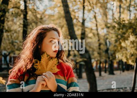 Body Shaming, Low self-worth concept. Sad plus size woman walking in autumn park. Stock Photo