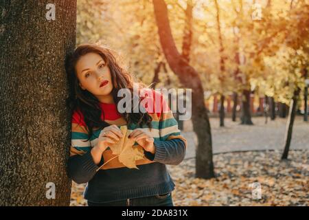 Body Shaming, Low self-worth concept. Sad plus size woman walking in autumn park. Stock Photo