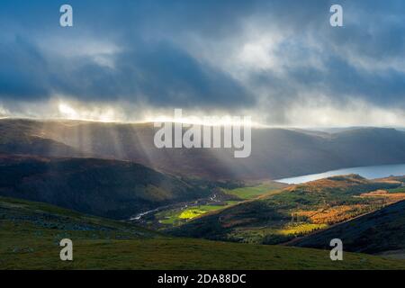 Rays / shafts of sunlight through clouds above Ennerdale Water. Lake District National Park, Cumbria, UK Stock Photo