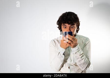 Young Hispanic man wearing casual clothes on a white background with a shocked expression Stock Photo