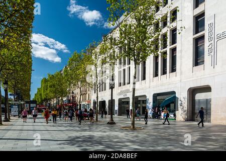 Paris, France - August 29, 2019 : Locals and tourists walking along crowded Champs-Elysees street sidewalk and storefronts, with luxury stores. Stock Photo