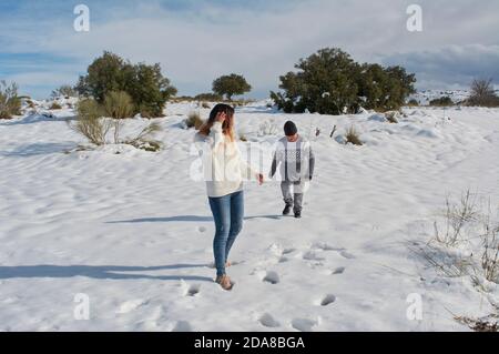 happy family, mother and son playing in the snow on a sunny day Stock Photo