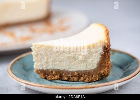 Slice Of Classical New York Cheesecake On A Blue Plate, Closeup View, Selective Focus Stock Photo