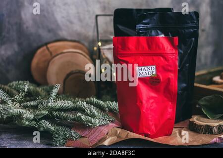 Black and red zip lock packs with hand made contents. Christmas decorations on the grey concrete background. Stock Photo