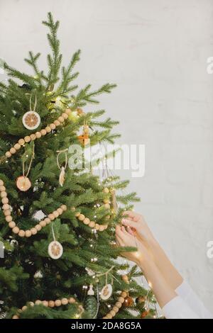 Close up of woman hands decorating Christmas tree. Stock Photo