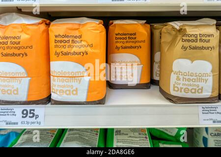 Bags of bread flour for sale on the shelves of a Sainsbury's supermarket.